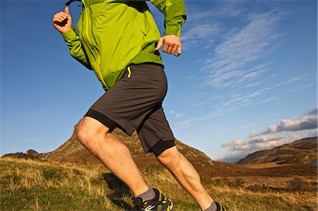 Hiker running up grassy hillside Foto de stock - Sin royalties Premium, Código: 649-06165056