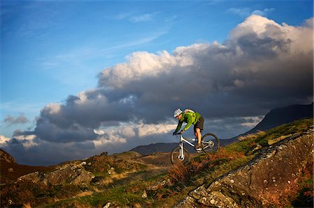 Mountain biker on grassy hillside Foto de stock - Sin royalties Premium, Código: 649-06165063