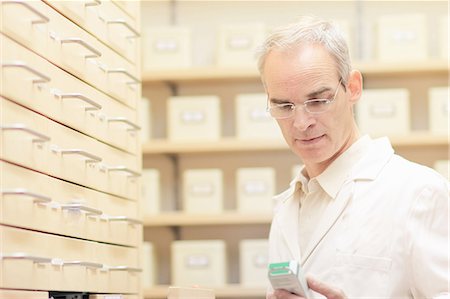 pharmacist (male) - Pharmacist examining box of pills Stock Photo - Premium Royalty-Free, Code: 649-06165161