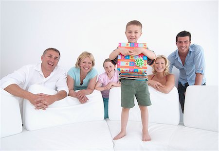 Boy opening gift with family Stock Photo - Premium Royalty-Free, Code: 649-06165185