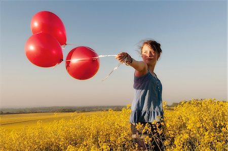 person walking field flowers - Girl carrying balloons in field Stock Photo - Premium Royalty-Free, Code: 649-06165186