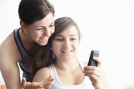 simsearch:6109-06003316,k - Teenage girls using cell phone together Fotografie stock - Premium Royalty-Free, Codice: 649-06165180