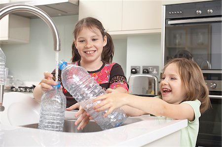 recycle children - Girls filling up water bottle in kitchen Foto de stock - Sin royalties Premium, Código: 649-06165199