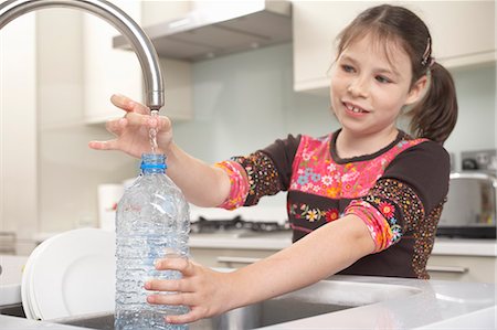 Girl filling up water bottle in kitchen Stock Photo - Premium Royalty-Free, Code: 649-06165191
