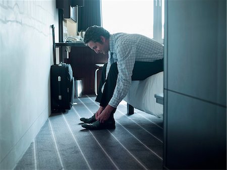 sitting suitcase - Businessman tying his shoes Stock Photo - Premium Royalty-Free, Code: 649-06165249