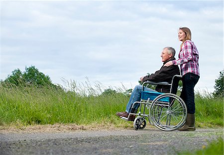 fauteuil roulant - Père poussant de femme en fauteuil roulant Photographie de stock - Premium Libres de Droits, Code: 649-06304859