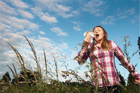 estornudar - Woman sneezing in tall grass Foto de stock - Sin royalties Premium, Código: 649-06304861