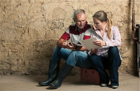 Father and daughter examining papers Stock Photo - Premium Royalty-Free, Code: 649-06304892