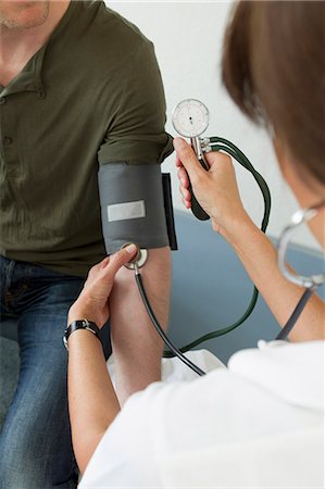 simsearch:649-03774459,k - Doctor taking patients blood pressure Foto de stock - Sin royalties Premium, Código: 649-06304910