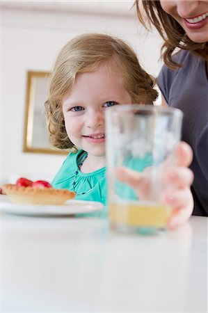 Girl holding glass of juice on table Stock Photo - Premium Royalty-Free, Code: 649-06304945