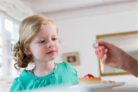 eating strawberry - Woman feeding daughter breakfast Stock Photo - Premium Royalty-Free, Code: 649-06304947