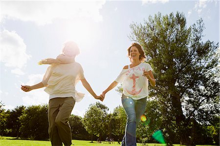 simsearch:649-06532681,k - Smiling women running outdoors Foto de stock - Sin royalties Premium, Código: 649-06305014