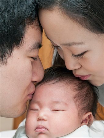 dad holding newborn baby - Parents s'embrasser le bébé qui dort Photographie de stock - Premium Libres de Droits, Code: 649-06305035