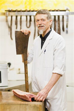 Butcher holding large knife and meat Fotografie stock - Premium Royalty-Free, Codice: 649-06305049