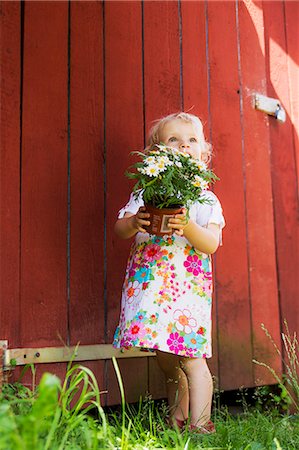 Girl holding potted plant outdoors Stock Photo - Premium Royalty-Free, Code: 649-06305095