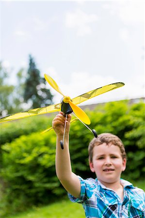 Boy playing with toy airplane outdoors Stock Photo - Premium Royalty-Free, Code: 649-06305099