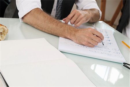 processing - Businessman taking notes at desk Stock Photo - Premium Royalty-Free, Code: 649-06305229