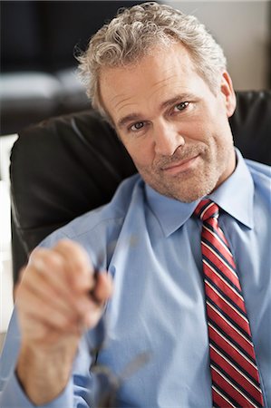 Serious businessman sitting at desk Foto de stock - Sin royalties Premium, Código: 649-06305242