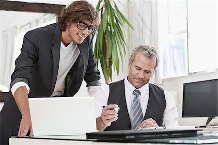 simsearch:649-06305244,k - Businessmen working together at desk Stock Photo - Premium Royalty-Free, Code: 649-06305271