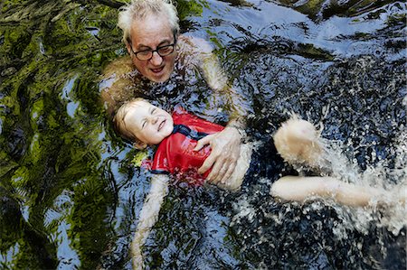 river motion - Older man teaching grandson to swim Stock Photo - Premium Royalty-Free, Code: 649-06305351