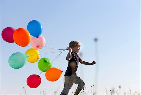 Garçon avec des ballons colorés dans l'herbe Photographie de stock - Premium Libres de Droits, Code: 649-06305405