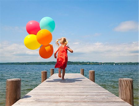 pigtails girl - Girl holding balloons on wooden pier Stock Photo - Premium Royalty-Free, Code: 649-06305422