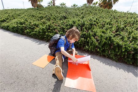 Boy pulling homework from folder Stock Photo - Premium Royalty-Free, Code: 649-06305510