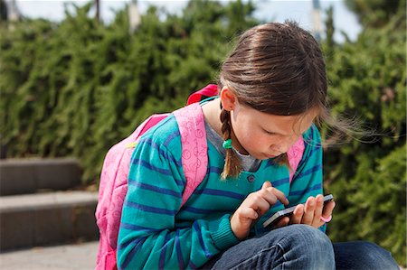 spain backpack - Girl using cell phone on steps outdoors Stock Photo - Premium Royalty-Free, Code: 649-06305513