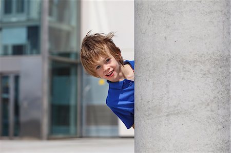 surprise boy - Boy peering out from behind column Foto de stock - Sin royalties Premium, Código: 649-06305520