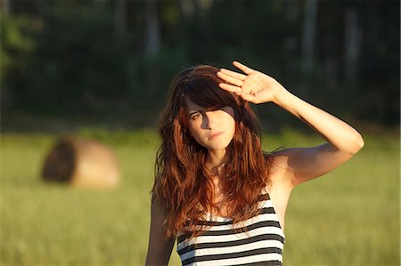 Woman shielding her eyes from sun Foto de stock - Sin royalties Premium, Código: 649-06305538