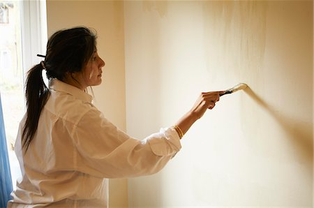 Woman painting room with paintbrush Stock Photo - Premium Royalty-Free, Code: 649-06305729