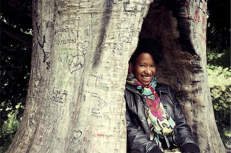 Smiling woman hiding in carved tree Stock Photo - Premium Royalty-Free, Code: 649-06305767