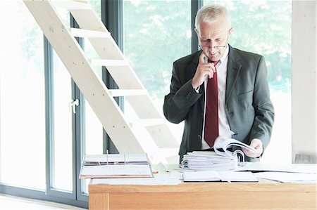 searching - Businessman leafing through binder Foto de stock - Sin royalties Premium, Código: 649-06305877