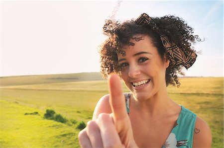 exuberant woman in sunlight - Smiling woman standing in meadow Stock Photo - Premium Royalty-Free, Code: 649-06305884