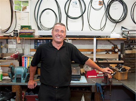 smiling blue collar guy - Worker smiling in workshop Stock Photo - Premium Royalty-Free, Code: 649-06305902