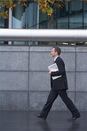 Businessman carrying paper outdoors Stock Photo - Premium Royalty-Free, Code: 649-06305932