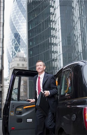 Businessman climbing out of taxi cab Stock Photo - Premium Royalty-Free, Code: 649-06305962