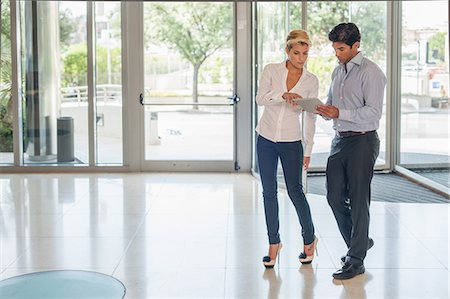 pointing at watch - Business people talking in lobby Stock Photo - Premium Royalty-Free, Code: 649-06352530