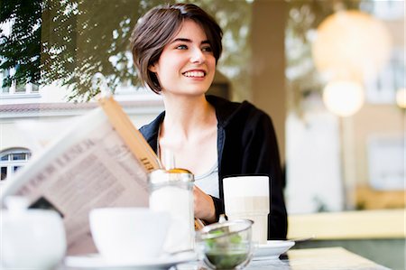 simsearch:649-06352541,k - Woman reading newspaper in cafe Foto de stock - Royalty Free Premium, Número: 649-06352545