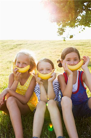 smile pose - Girls holding bananas over mouths Foto de stock - Sin royalties Premium, Código: 649-06352647