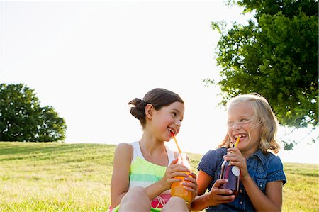 food bottles - Laughing girls drinking juice outdoors Foto de stock - Sin royalties Premium, Código: 649-06352650