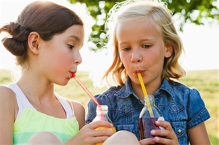 softdrink - Laughing girls drinking juice outdoors Stock Photo - Premium Royalty-Free, Code: 649-06352651