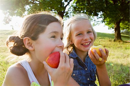 Laughing girls eating apples outdoors Foto de stock - Sin royalties Premium, Código: 649-06352653