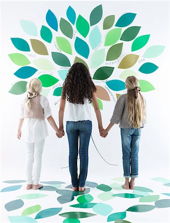 standing holding hands picture - Girls writing on tree on wall Stock Photo - Premium Royalty-Free, Code: 649-06352957