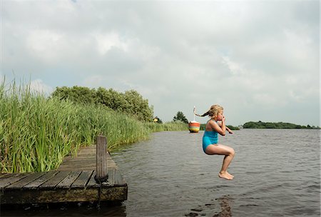 dock girl - Girl jumping into rural lake Stock Photo - Premium Royalty-Free, Code: 649-06352994