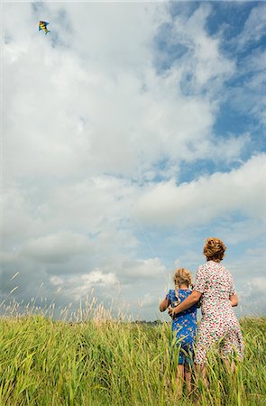 person looking up at sky clouds - Mère et fille flying kite dans le champ Photographie de stock - Premium Libres de Droits, Code: 649-06353006