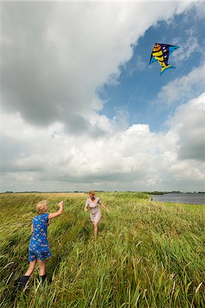 flying women - Mother and daughter flying kite in field Stock Photo - Premium Royalty-Free, Code: 649-06353001