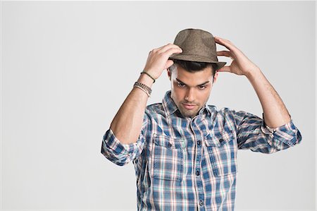 posición - Man trying on hat Foto de stock - Sin royalties Premium, Código: 649-06353169