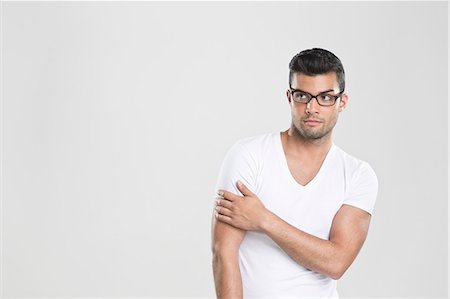 standing man not smiling - Curious man holding arm Stock Photo - Premium Royalty-Free, Code: 649-06353179