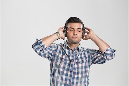 posición - Man listening to headphones Foto de stock - Sin royalties Premium, Código: 649-06353172
